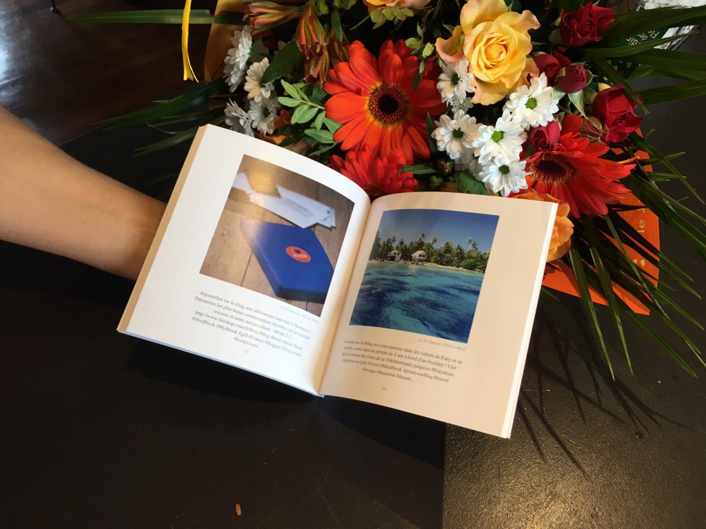 A paper book opened in front of flowers 