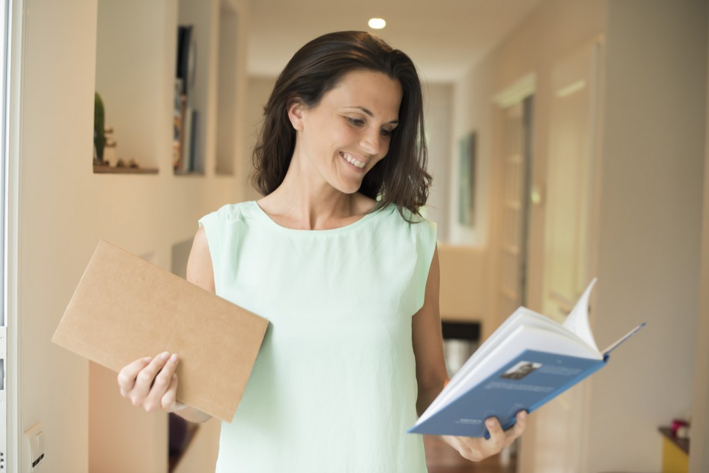 Person holding two books and smiling 