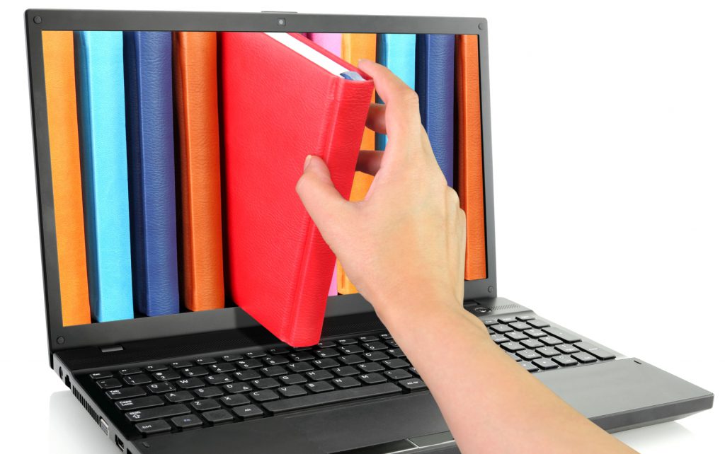 a hand taking a book out of a digital library 