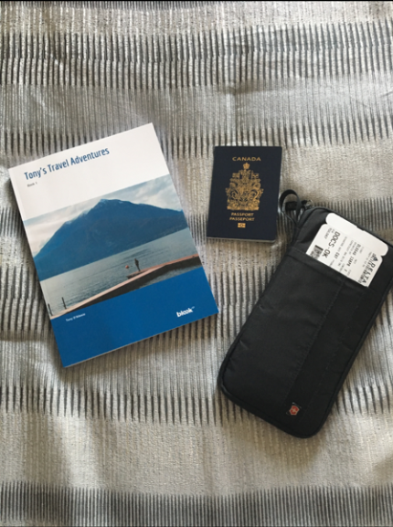 a blook a passport and a boarding pass on a bed