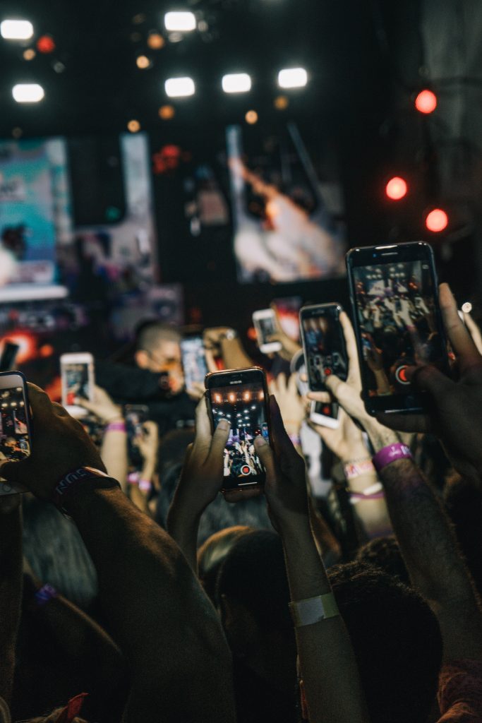 poeple holding their phones in the air recording on their instagram stories