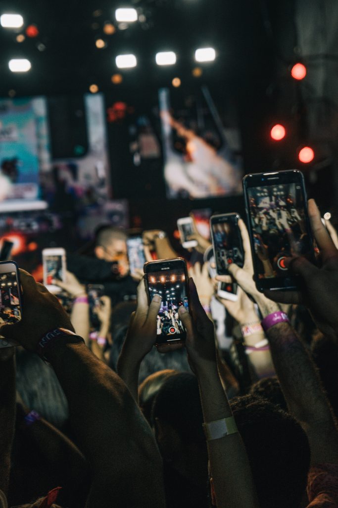 poeple holding their phones in the air recording on their instagram stories 