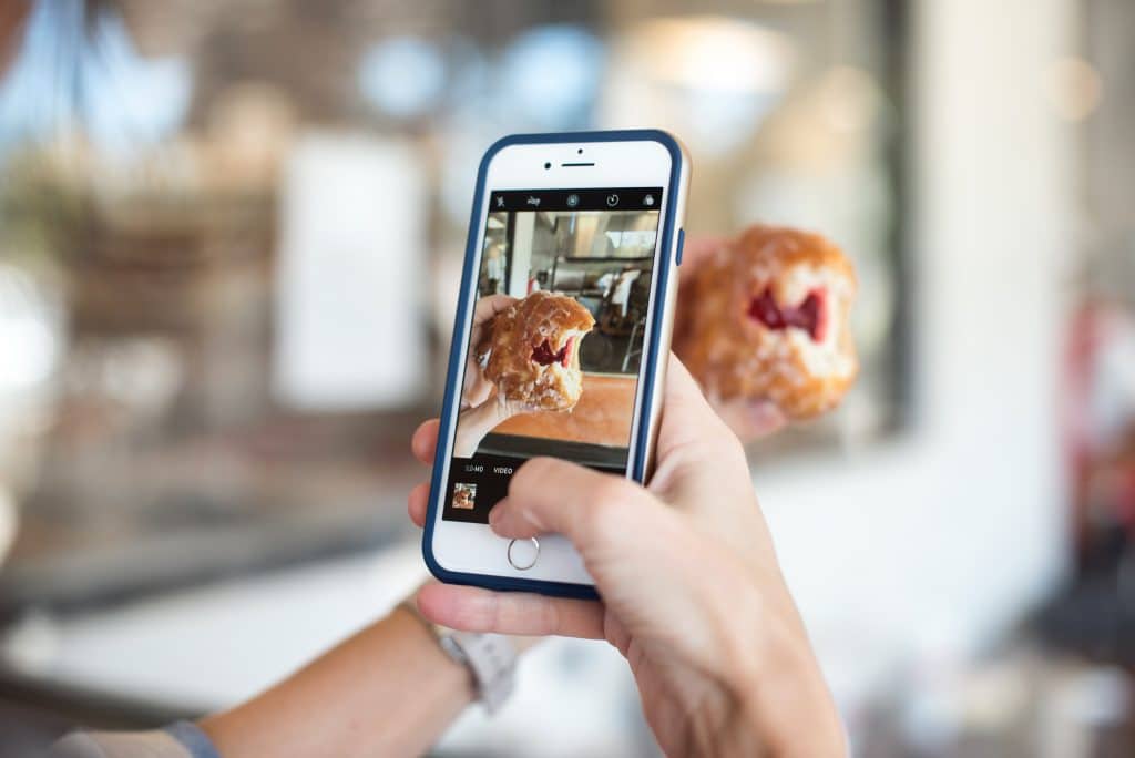 A person taking a picture of food on their instagram story 