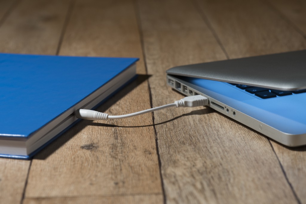 A paper book connected to a computer 